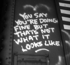 graffiti is spray painted on the side of a train car that says, you say you're doing fine but that's not what it looks like