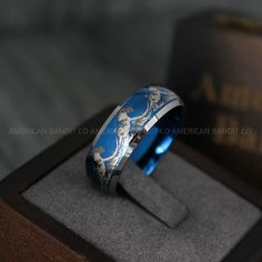 a blue and white ring sitting on top of a wooden box