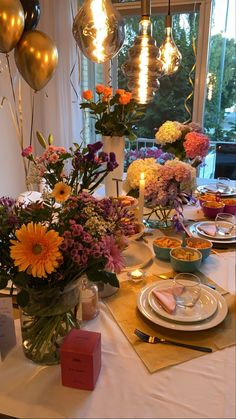 the table is set with flowers, plates and candles for an elegant dinner or brunch