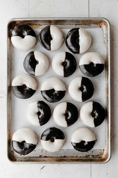 doughnuts with black and white frosting on a baking sheet