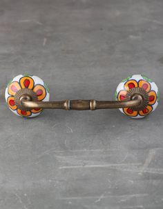 an old wooden handle with flowers painted on it's sides and metal bar at the end