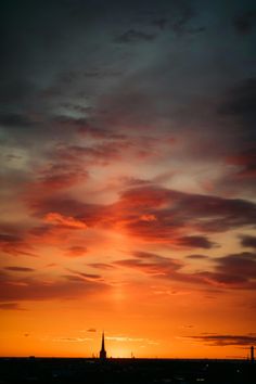 the sun is setting behind some clouds in the sky