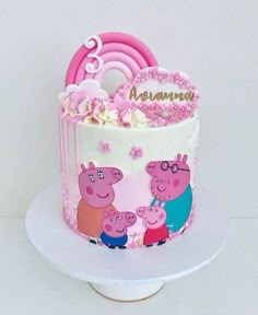 a peppa pig birthday cake with pink frosting and flowers on top, sitting on a white plate