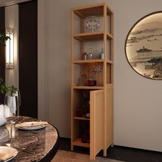 a dining room table with plates and wine glasses on it, next to a china cabinet