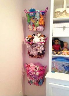 there is a shelf with stuffed animals and toys in baskets on the wall next to it