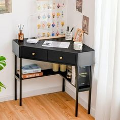 a black desk with some books on it and a potted plant in the corner