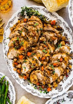 a white plate topped with chicken and veggies next to other plates of food