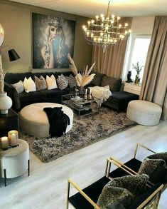 a living room filled with furniture and a chandelier hanging over the top of it