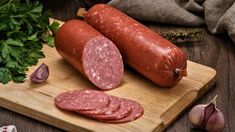 two large sausages on a cutting board next to garlic, parsley and pepper