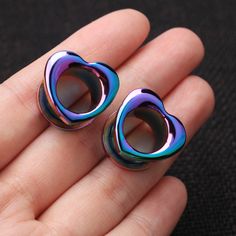 pair of colorful heart shaped earrings sitting on someone's hand