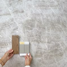 a woman is painting the wall with gray and white paint on it's walls