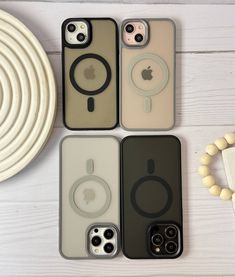 four iphone cases sitting next to each other on top of a white table with an apple phone