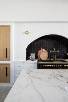 a kitchen with marble counter tops and wooden cabinets, along with an oven in the center