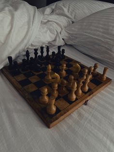 a wooden chess set on top of a bed