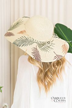 a woman wearing a white hat with palm leaves on it and the words uniquely caudia