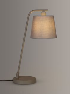 a table lamp with a white shade on the base and a black cord attached to it