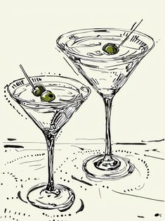 two martini glasses with olives in them