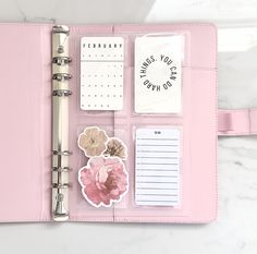 a pink planner with stickers and notes on it