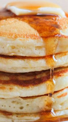 a stack of pancakes covered in syrup on top of a white plate