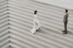 a bride and groom walking up some steps