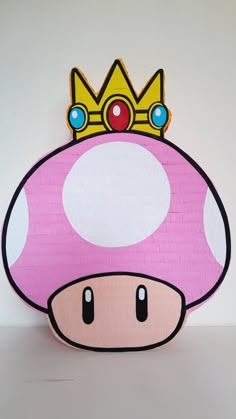 a paper mario mushroom with a crown on it's head, sitting in front of a white wall