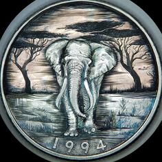 an elephant is depicted on a coin with trees in the background and water running through it