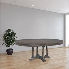 a round table sitting on top of a wooden floor next to a potted plant