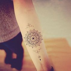 a woman's arm with a tattoo on it that has an image of a flower in the center