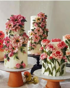 there are three cakes decorated with flowers on the table