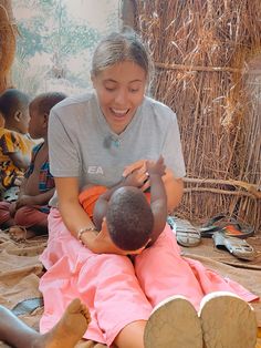 a woman sitting on the ground with a child