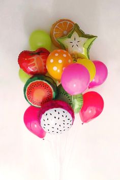 a bunch of balloons that are in the shape of watermelon and kiwi