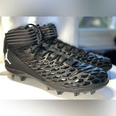 a pair of black soccer shoes sitting on top of a table