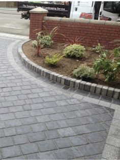 a brick walkway with landscaping around it