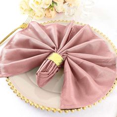 a pink napkin on top of a white plate