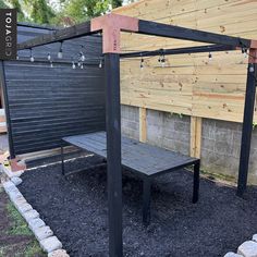 a wooden bench sitting in the middle of a gravel covered area next to a fence