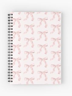 a spiral notebook with pink bows on it