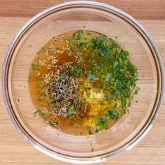 a bowl filled with soup and garnishes on top of a wooden table