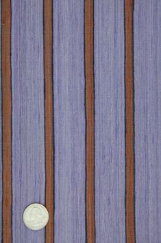 a purple and brown striped wallpaper with a small white button