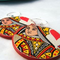 two wooden earrings with pictures of women on them