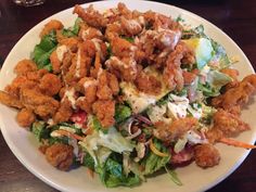 a white plate topped with salad and fried chicken