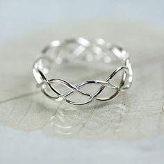 For a touch of classic style and eternal symbolism this Celtic braided ring is just right. Suitable for both men and women the design has endured through the ages for a reason. This ring is hand woven and looks it. Small variations in the bends and turns makes every one of them unique and rustic looking. This ring is very tactile and good for playing with when you need a moment to think. This ring is about 5 mm wide with a wire thickness of 0.9 mm For a wider version of the braid ring at about 7 Celtic Rings Women, Silver Braided Ring, The Bends, Silver Celtic Rings, Twist Jewelry, Celtic Ring, Handmade Silver Jewellery, Silver Bracelets For Women, Layered Necklaces Silver