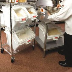 a man in a kitchen preparing food on top of a metal shelf with bins