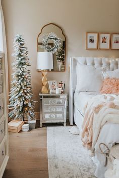 a bedroom decorated for christmas with white and gold decor