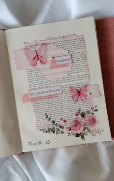 an open book with pink flowers and butterflies on it