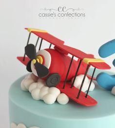 a cake decorated with an airplane and clouds