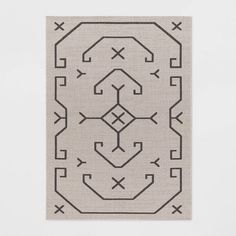 a black and white rug with an intricate design on the bottom, in front of a white wall