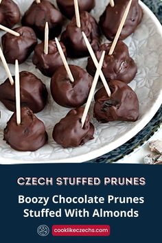 chocolate covered prunes are arranged on a plate with toothpicks in the middle