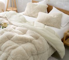 a bed with white blankets and pillows on it