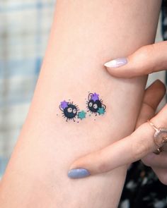 a woman's arm with two small tattoos on it