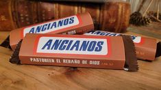 three pieces of chocolate bar sitting on top of a wooden table next to some books